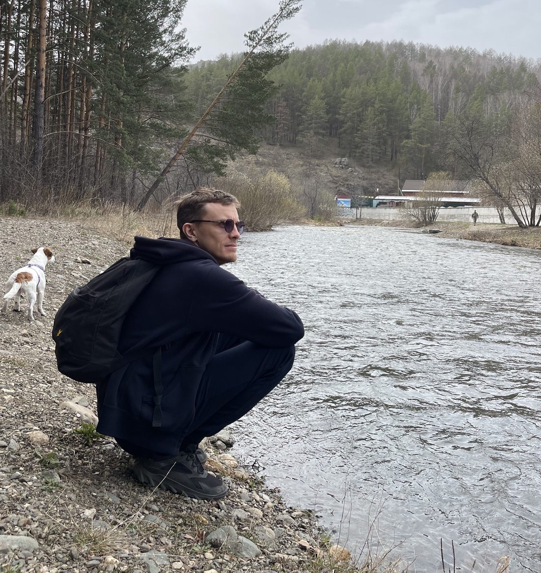 Алексей, автор сайта, сидит на берегу горной реки